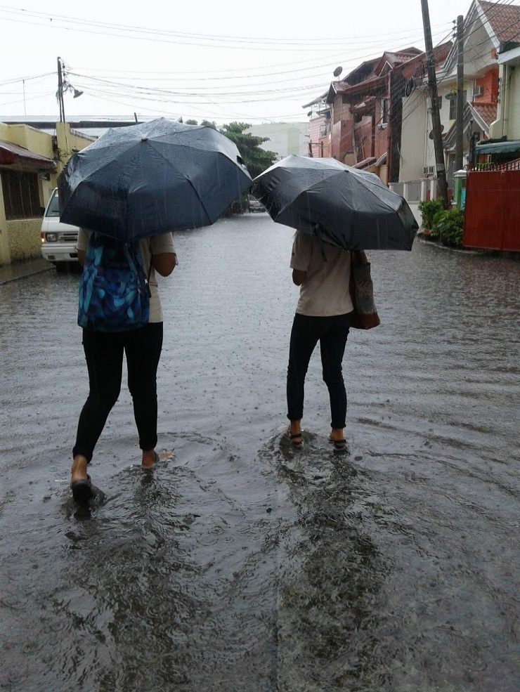 Field workers trod a flooded road to reach their target respondents [Olongapo City, Zambales; July 2018]