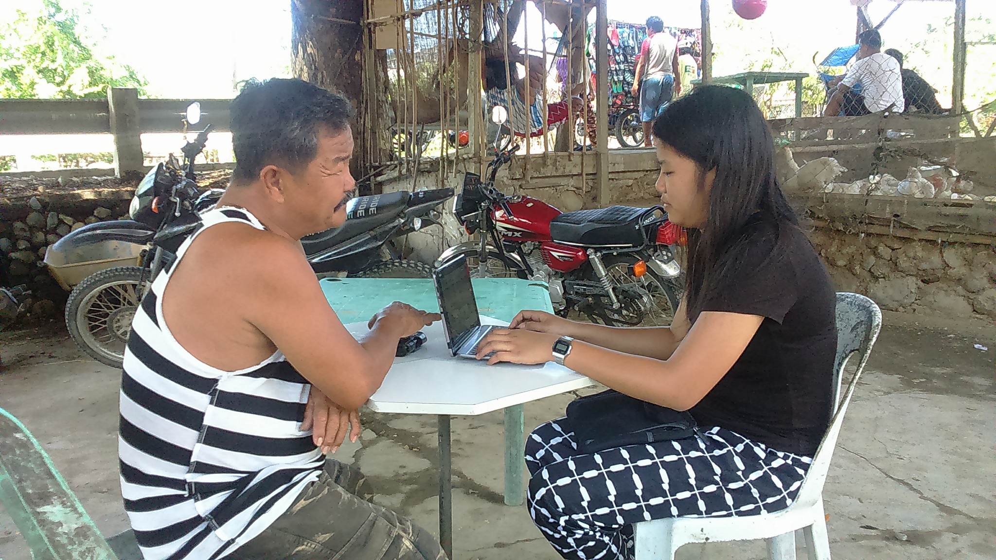 A female field worker interviews a male respondent using CAPI in a rural barangay in Ilocos Norte